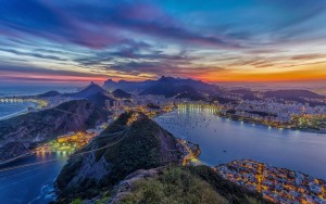 Sunset over Rio de Janeiro with mountains and city lights.