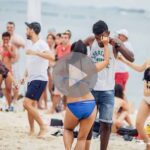 People enjoying a sunny day at the beach in swimwear.