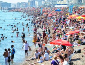 Crowded beach with many people enjoying the water and sun.